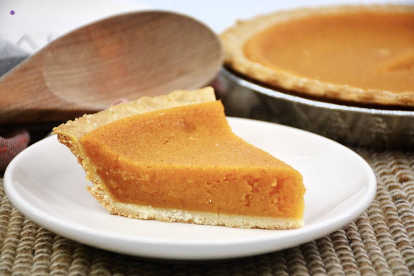Homemade sweet potato pie with whipped cream and cinnamon